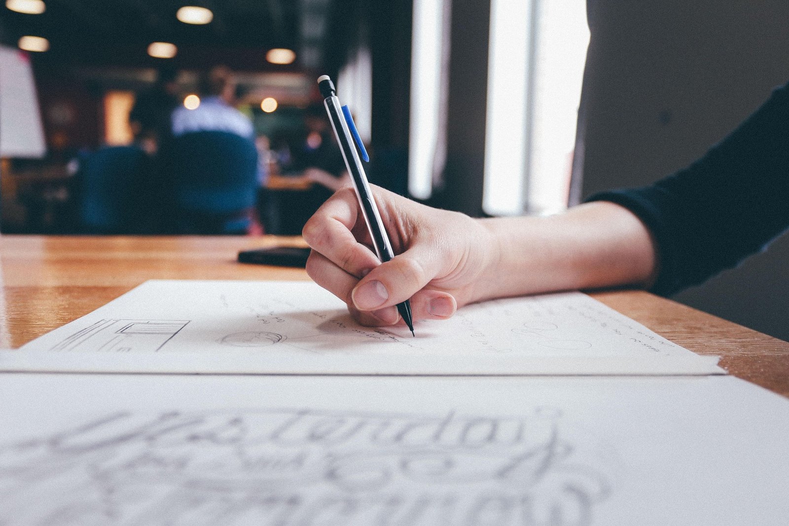 Mano escribiendo y esbozando una estrategia de marketing en papel para entrenar el pensamiento estratégico
